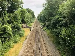 A pair of railway tracks leading away from the viewer, crossing another railway line in the centre of the image