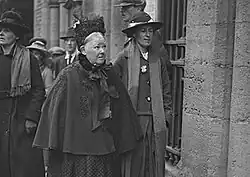 Photograph of Swan, wearing a coat and hat, with her elderly mother, also wearing a coat and hat