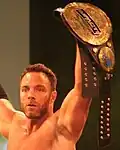 Eli Drake with a modified version of the fourth title belt design; which added an "Impact Wrestling" plate to the title belt to cover the Global Force Wrestling logo after the company's brief use of that name.