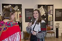 A volunteer woman explains about traditional Ukrainian embroidery in the Ukrainian Museum of Canada, Ontario Branch, 2023.