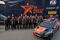 FIA Rally Star team posing in front of the team truck and car at the end of their training camp in Sardinia 2023