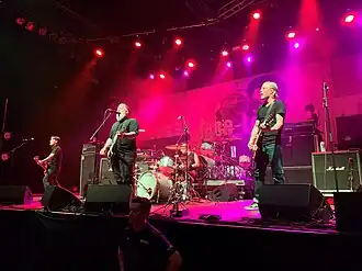 Face to Face performing at the Fillmore Auditorium in Denver, 2022 Left to right: Shiflett, Keith, ex-drummer Parada (behind drum kit), and Hill.