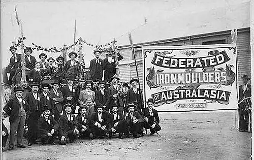 Members of the Bendigo Branch of Ironmoulders Union, standing next to a union banner at a celebration or procession