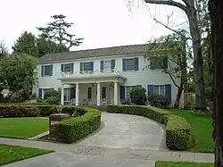 A white house with blue shutters is pictured