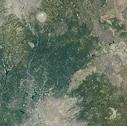 A satellite image from 2001 shows a distinct brown fire scar surrounded by green