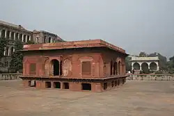 Square red sandstone building in a dried-out water tank