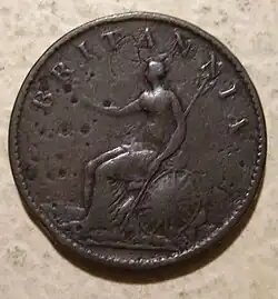 A worn copper coin with Britannia on it
