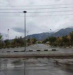a road surrounded by trees with mountains in the background