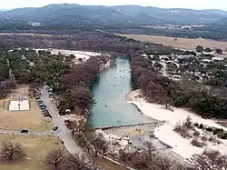 The Frio River winds along the east side of Garner State Park (on the left, showing a dam that forms a swimming area).
