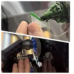 Dent being removed with glue applied to plastic tab and adhered to vehicle