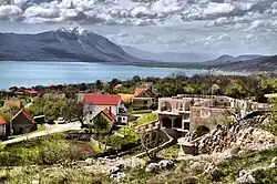 A skyline of the village, with a lake and mountains in the background