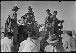 Granada Relocation Center Boy Scouts help with the check baggage in September 1943