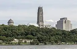 A landscape of Riverside Park; behind the park's trees is the tower of Riverside Church, at center