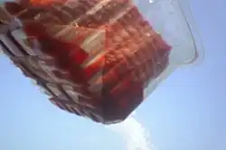 A meat absorbent pad, seen absorbing liquids from ground meat