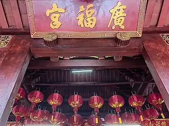 The main signboard reading “廣福宮” (Guangfu Gong) with hanging red lanterns beneath.