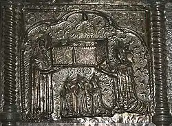 Woman handing a sarcophagus to a saint with her three daughters kneeling in front of her