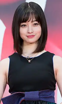 Kanna Hashimoto in sleeveless dress facing camera with arms lowered and hands folded in front of body
