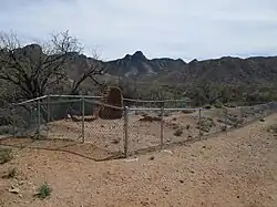 The fenced-in ruins of an adobe hotel in Helvetia.