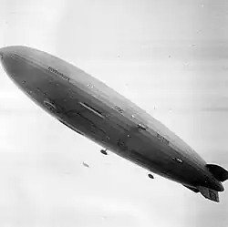 LZ 129 Hindenburg flying over the village, with the Olympics logo painted on its underside hull