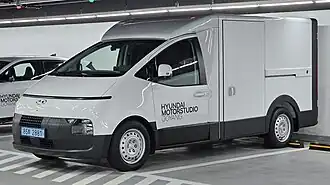 A white Hyundai ST1 parked in an indoor parking garage. Front three-quarters view of the vehicle, which is parked with the rear facing the wall.