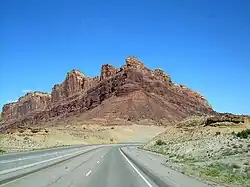 A mountain made from two layers of sandstone, the lower layer is a light color, while the upper layer is dark red.