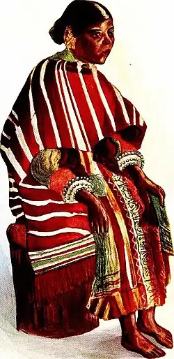This iamge depicts a War Woman of Shili, now known as Shella. The traditional attire of the people of Mustoh and Shella includes a wraparound called the Jainpien and a shawl called the Jainkup, both made from handwoven Eri silk embroidered with Khneng. This image provides evidence of the Thohkhyrwang pattern of Eri silk, which features mauve and pale brown hues.