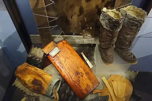 Top right, kamik for wet conditions, from Ungava, 1989. Note wrap-around sole, seam location, and lack of laces (close-up). Left, the tools for making them. Lower right, cut-out pieces for sole and vamp.