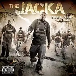 The cover features the Jacka wearing a long black shirt, black jeans and a black bulletproof vest, walking through a ravaged street with people wearing similar gear behind him. The artist's name appears above him and the album title is placed on the right side of the cover, colored in orange and white respectively.