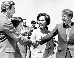 Carter shaking hands with Reubin Askew, with Carter's wife smiling while standing in the middle of them