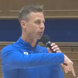 Headshot of Scheyer delivering an address with a microphone