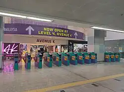 The fare gates to/from the station. The Avenue K shopping mall's concourse level can be seen.