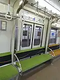 Stowable seats where they retract into the ceiling when stored, Keihan 5000 series.