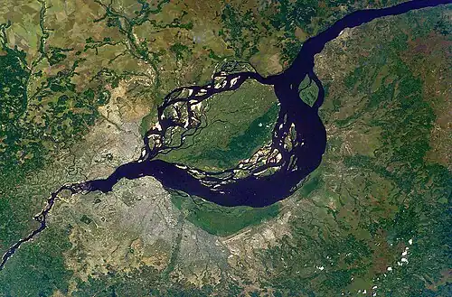 Satellite image of the Congo River. A large urban area is visible along its south bank, and a smaller one is visible along the north.