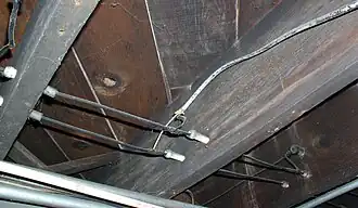 Wiring running through tubes, and turning a corner supported by a knob. Notice the direct splice with more modern (1950s-era) non-metallic–sheathed cable. This type of connection is forbidden by the National Electrical Code, and a junction box should have been used.