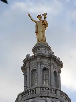 Golden statue of a standing woman holding a torch