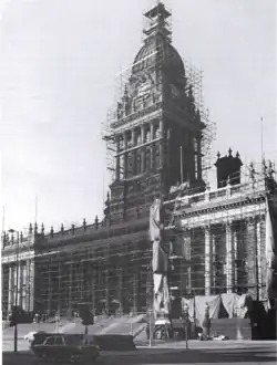 B&W photograph of a scaffolding-covered Town Hall undergoing cleaning