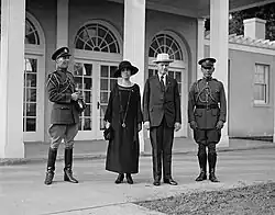 Photograph of the president and first lady standing between two men in uniform