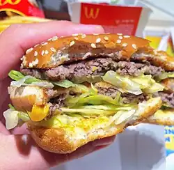 A half-eaten McDonald's Big Mac, showing the contents of the burger