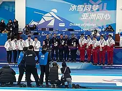A podium of fifteen curlers being awarded medals.