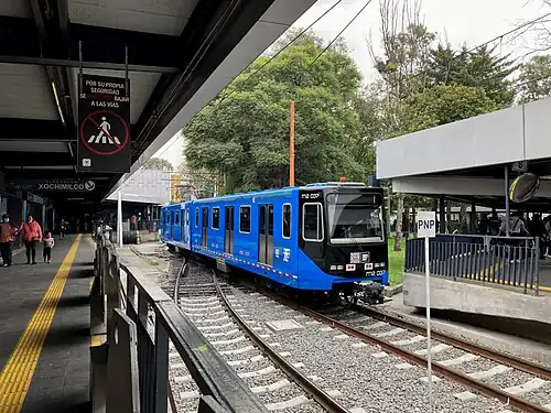 An almost empty train platform. A train is in the tracks.