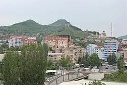 View of North Mitrovica; Zvečan Fortress on the mountain to the left, Trepča chimney on the right, and Ibar Bridge in the center.