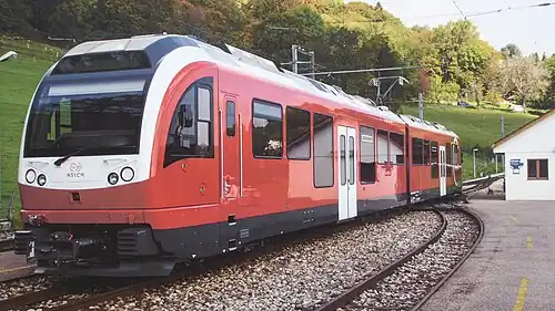 Red and white train next to a white station shelter