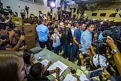 Nayib Bukele and Gabriela Rodríguez posing for press photographers at a campaign rally