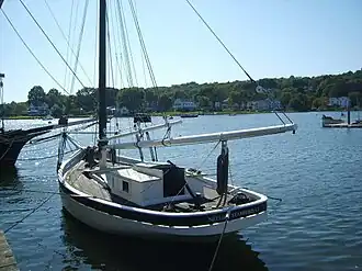 Nellie at a pier viewed from her port stern quarter.