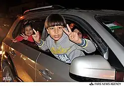 Children making peace symbol in a car, celebrating a ceasefire in November 2012, Gaza