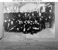 Wood as a lieutenant, seated on the deck in the front row on the right in this photograph of the officers of the protected cruiser USS Chicago, c. 1903
