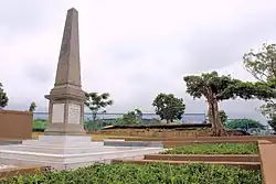 A photograph taken in 2014 of a large memorial within a school surrounded by trees.