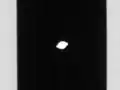 Pan in the center of the image, occupying the Encke Gap in Saturn's rings. Its walnut-like shape is clearly visible.