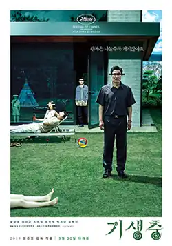 A man stands on a lawn, his eyes censored by a black line, as are those of a boy behind him. A younger couple of people relax on a sun lounger, their eyes covered by a white line. Someone's legs, lying on the grass, enter the frame. There is Korean text above the man's head as well as in the white margin below the picture.