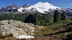 Snow-capped mountain in background with rocky path in foreground